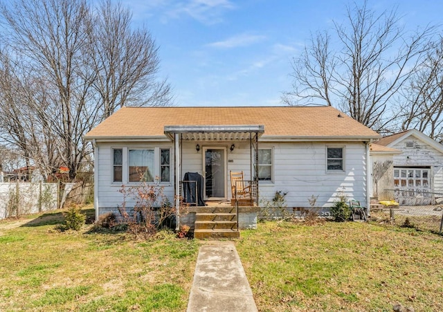 bungalow-style house featuring a front yard and fence