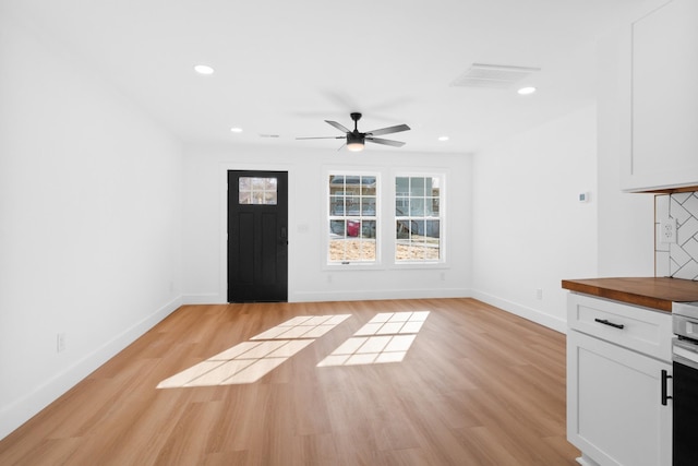 foyer with recessed lighting, light wood-style flooring, and baseboards