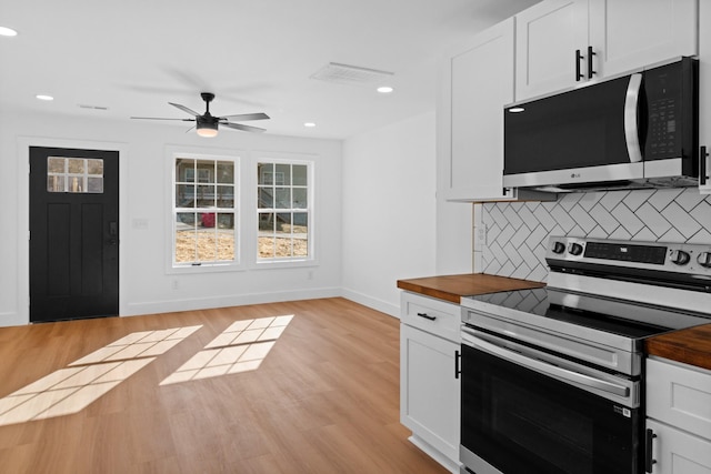 kitchen featuring backsplash, light wood-type flooring, appliances with stainless steel finishes, and wood counters