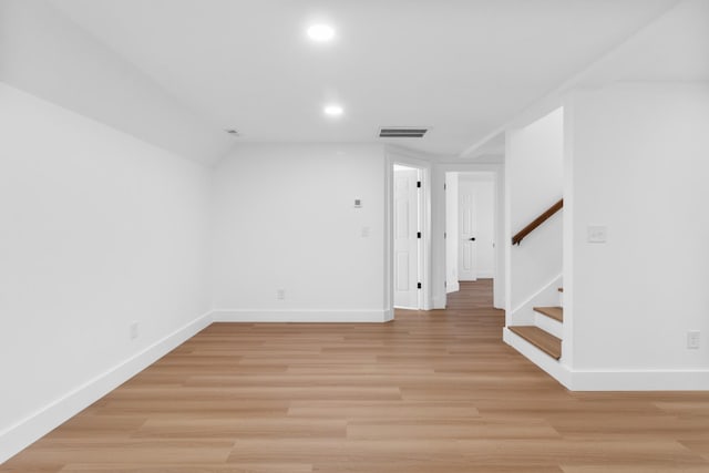 empty room with visible vents, baseboards, recessed lighting, stairs, and light wood-style floors