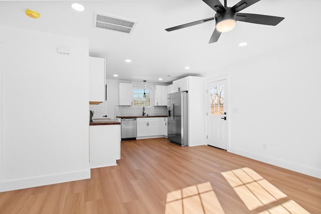 kitchen featuring dark countertops, a wealth of natural light, visible vents, and appliances with stainless steel finishes