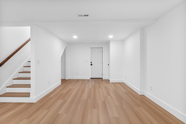 below grade area with stairway, visible vents, baseboards, light wood finished floors, and recessed lighting