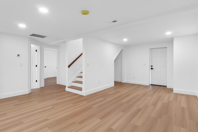 finished basement with stairway, recessed lighting, visible vents, and light wood-type flooring