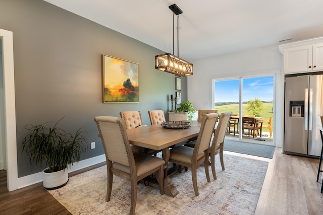 dining room featuring baseboards and light wood-type flooring