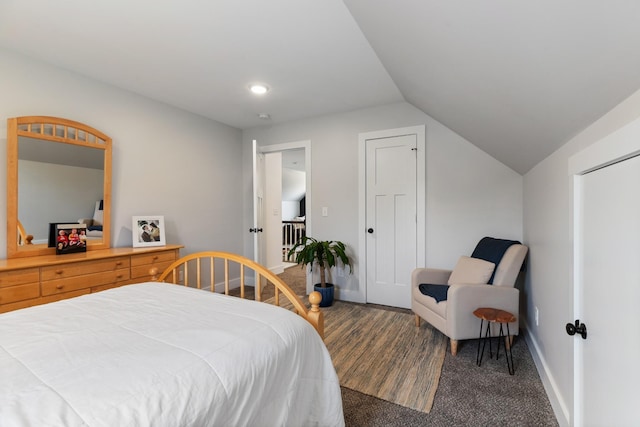 bedroom featuring baseboards, lofted ceiling, and carpet floors