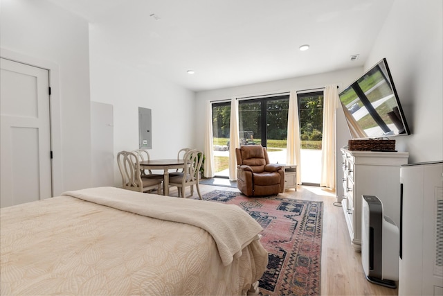 bedroom featuring electric panel, recessed lighting, light wood-style flooring, and access to outside