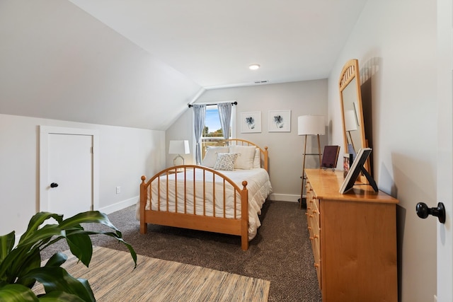 bedroom featuring dark carpet, baseboards, and vaulted ceiling