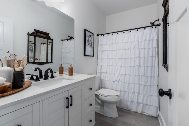 bathroom featuring curtained shower, toilet, wood finished floors, and vanity