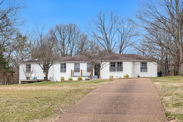 ranch-style home with brick siding, driveway, and a front lawn