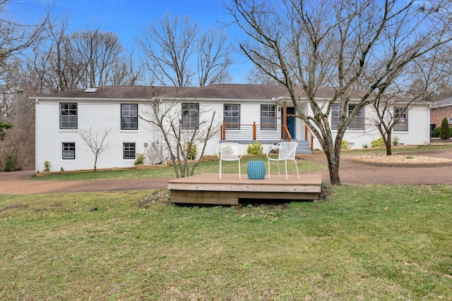 rear view of property with a lawn and brick siding