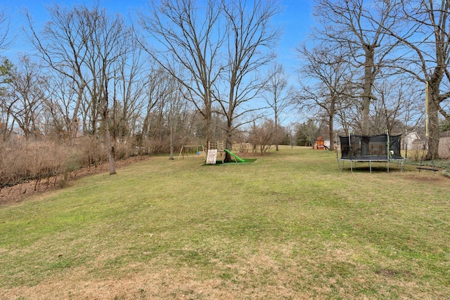 view of yard with a playground and a trampoline