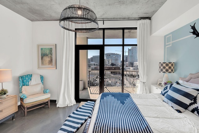 bedroom with access to exterior, a city view, and concrete flooring