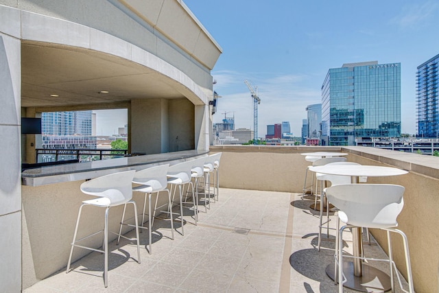 view of patio featuring outdoor dry bar and a city view