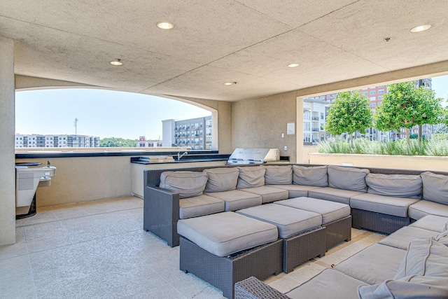 view of patio featuring area for grilling, a view of city, outdoor lounge area, and a sink