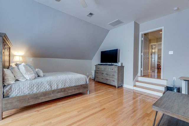 bedroom with a ceiling fan, visible vents, baseboards, light wood-style flooring, and vaulted ceiling