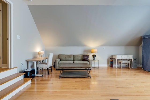 living area featuring vaulted ceiling, wood finished floors, and baseboards