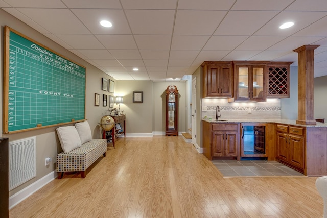 bar with visible vents, a sink, wine cooler, light wood-style floors, and wet bar