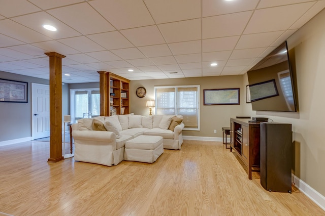 living area with ornate columns, recessed lighting, baseboards, and light wood-style floors