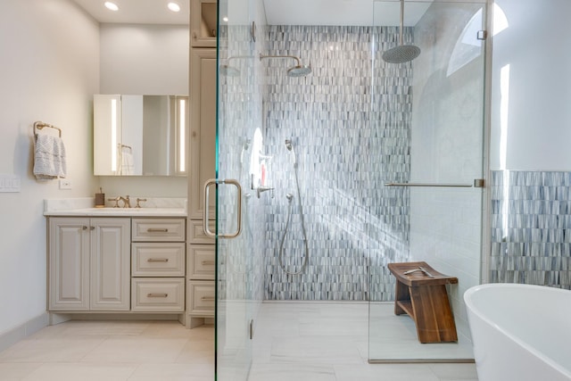 bathroom featuring a tile shower, tile walls, tile patterned flooring, a freestanding bath, and vanity