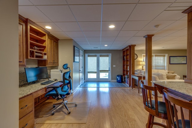 office with light wood finished floors, built in desk, recessed lighting, and baseboards