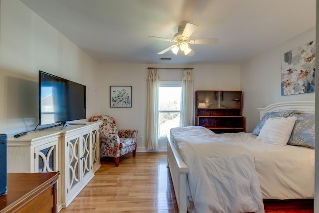 bedroom featuring light wood-type flooring, baseboards, visible vents, and ceiling fan