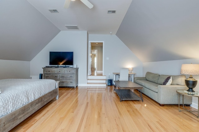 bedroom with vaulted ceiling, wood finished floors, and visible vents