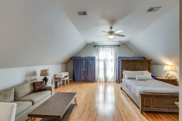 bedroom with visible vents, lofted ceiling, light wood-style flooring, and a ceiling fan