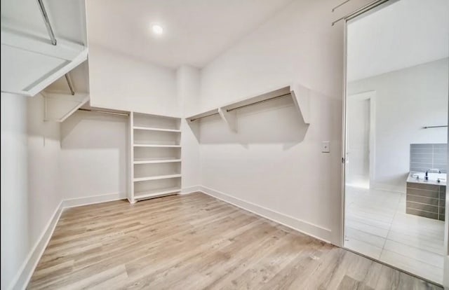 walk in closet with wood finished floors