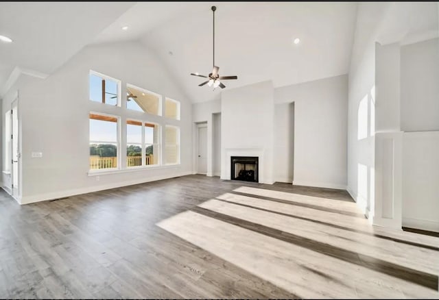 unfurnished living room featuring baseboards, ceiling fan, a fireplace, wood finished floors, and high vaulted ceiling