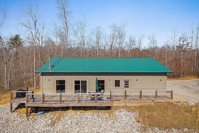 rear view of property featuring a deck and metal roof