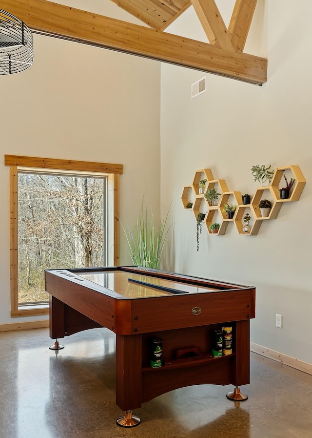 recreation room with baseboards, visible vents, concrete floors, and high vaulted ceiling