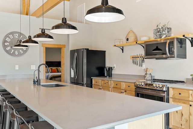 kitchen featuring a sink, a breakfast bar, light brown cabinetry, and stainless steel appliances