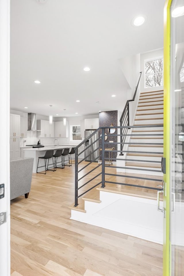 stairway with recessed lighting and wood finished floors