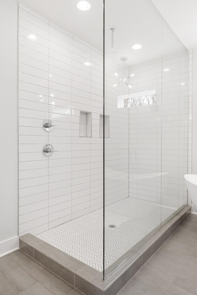 full bathroom featuring baseboards, a shower stall, and tile patterned flooring