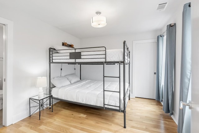 bedroom featuring wood finished floors and visible vents