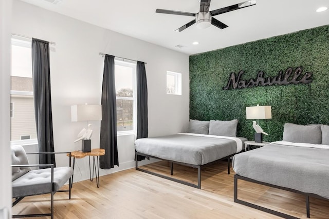 bedroom featuring wallpapered walls, an accent wall, ceiling fan, recessed lighting, and wood finished floors