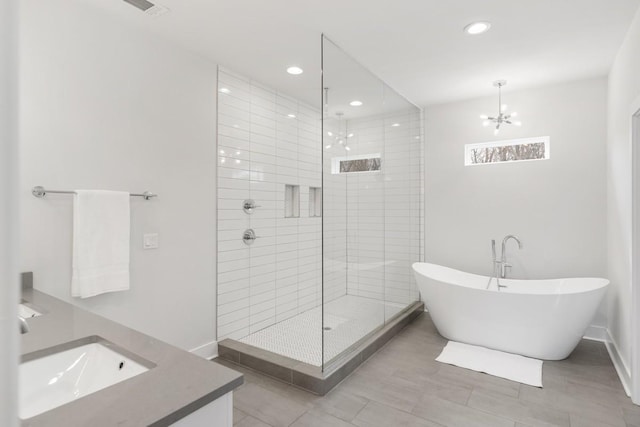 bathroom with a freestanding tub, visible vents, recessed lighting, baseboards, and tiled shower