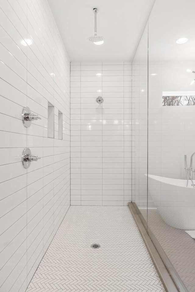 full bath featuring tile patterned flooring, a stall shower, and a freestanding bath