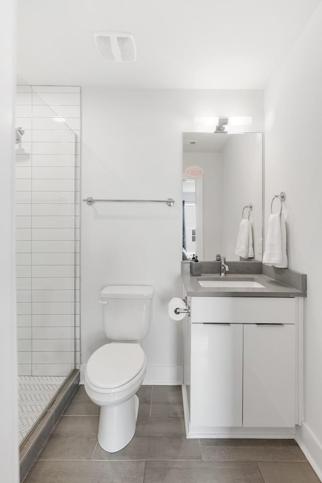 full bathroom with visible vents, toilet, a shower stall, baseboards, and vanity