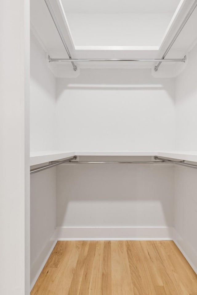 spacious closet with light wood-style floors and built in study area