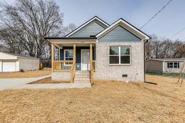 view of front of property with crawl space, covered porch, an outdoor structure, and brick siding