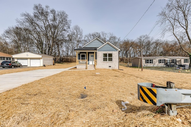 view of front of property featuring a detached garage, brick siding, an outdoor structure, and crawl space