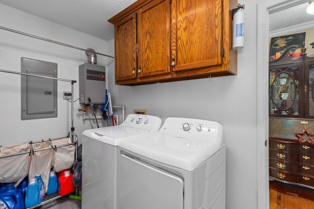 laundry area featuring electric panel, washer and dryer, a textured ceiling, water heater, and cabinet space