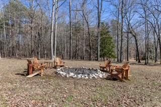 view of yard featuring a wooded view and an outdoor fire pit