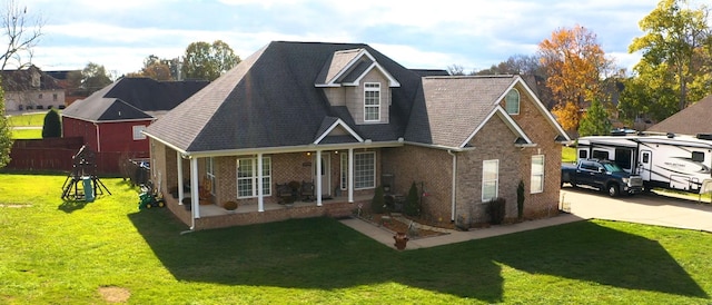 traditional home featuring a front yard, a patio, fence, concrete driveway, and brick siding