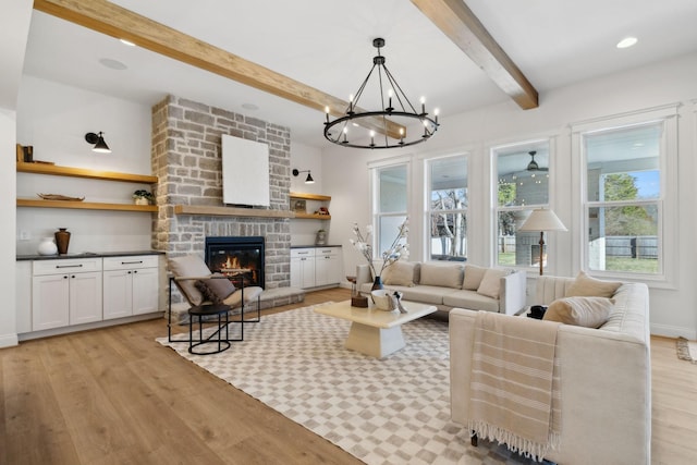 living room with a brick fireplace, baseboards, beamed ceiling, recessed lighting, and light wood-style floors