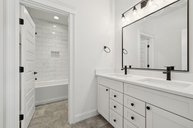 full bath with a sink, baseboards, and double vanity