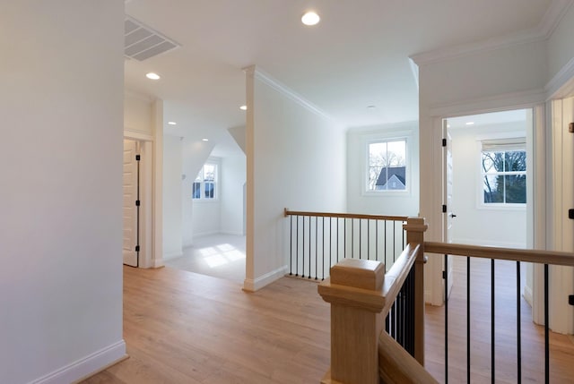 hallway with light wood-type flooring, an upstairs landing, ornamental molding, recessed lighting, and baseboards