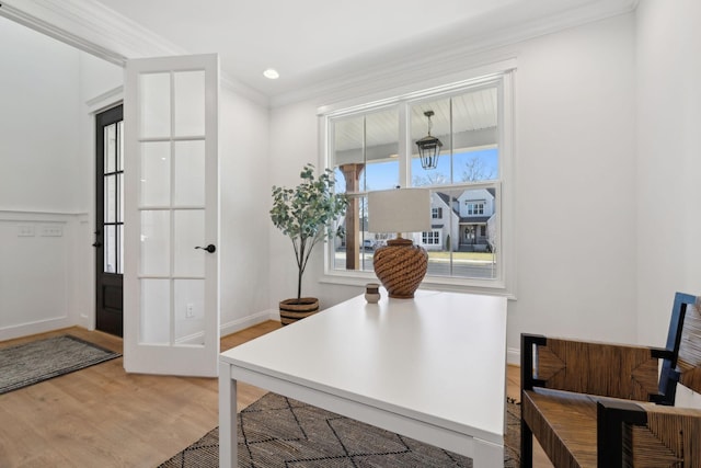 office area featuring crown molding, light wood-style floors, and baseboards