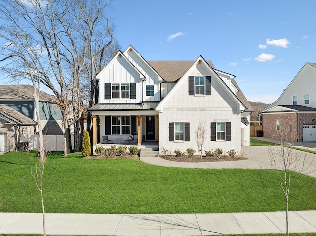 modern inspired farmhouse featuring a porch, fence, board and batten siding, a front yard, and brick siding